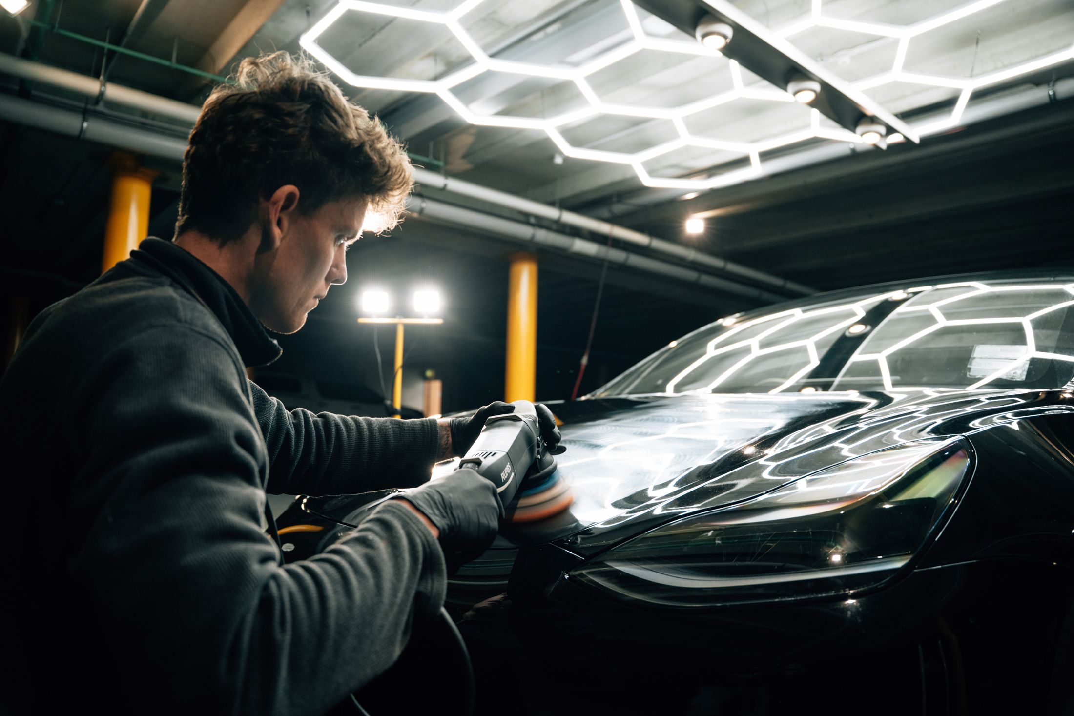 Mason machine polishing a bonnet under the hex lights at Glenda Drive