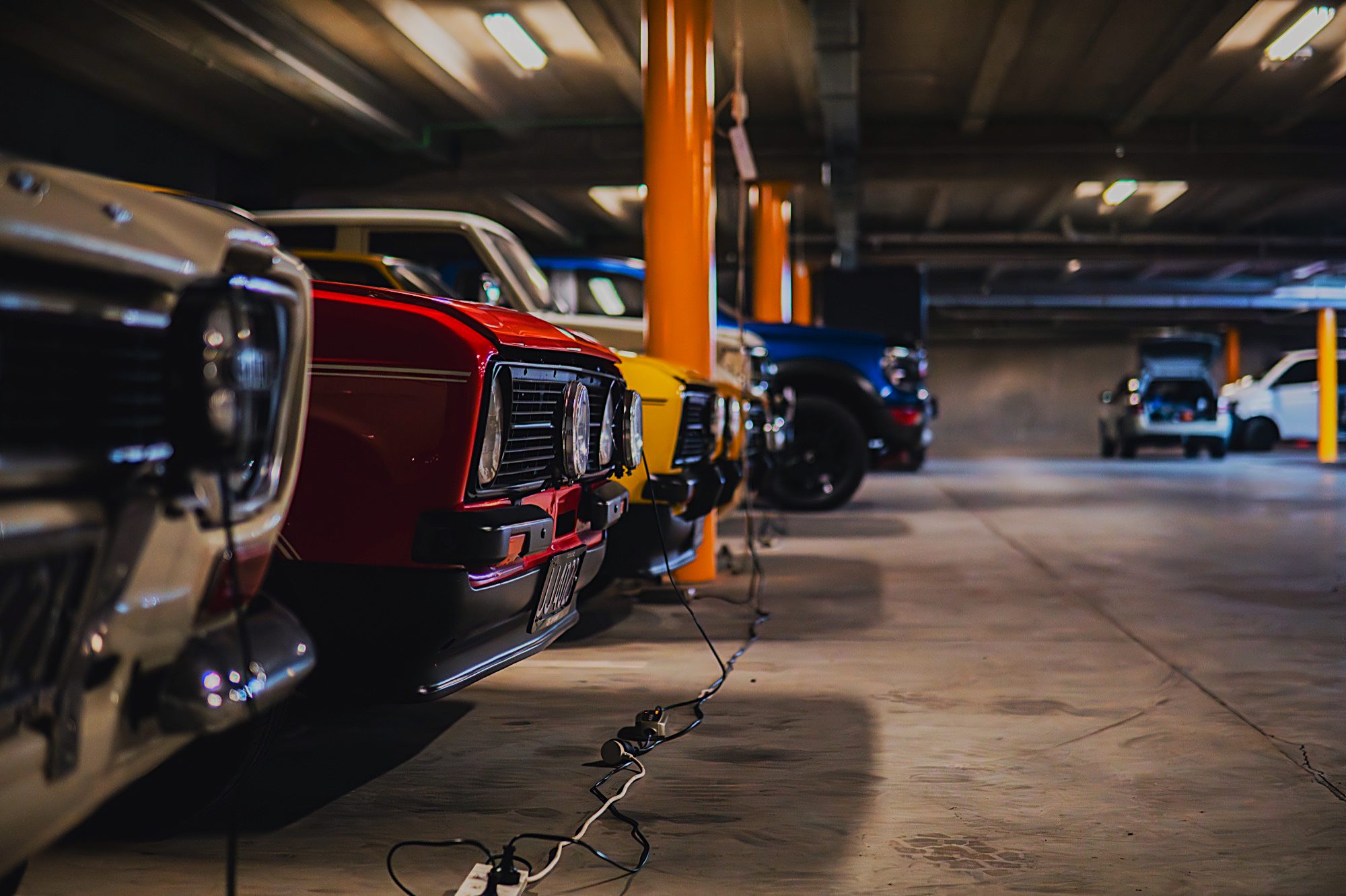 Front grilles of classic cars under workshop lighting